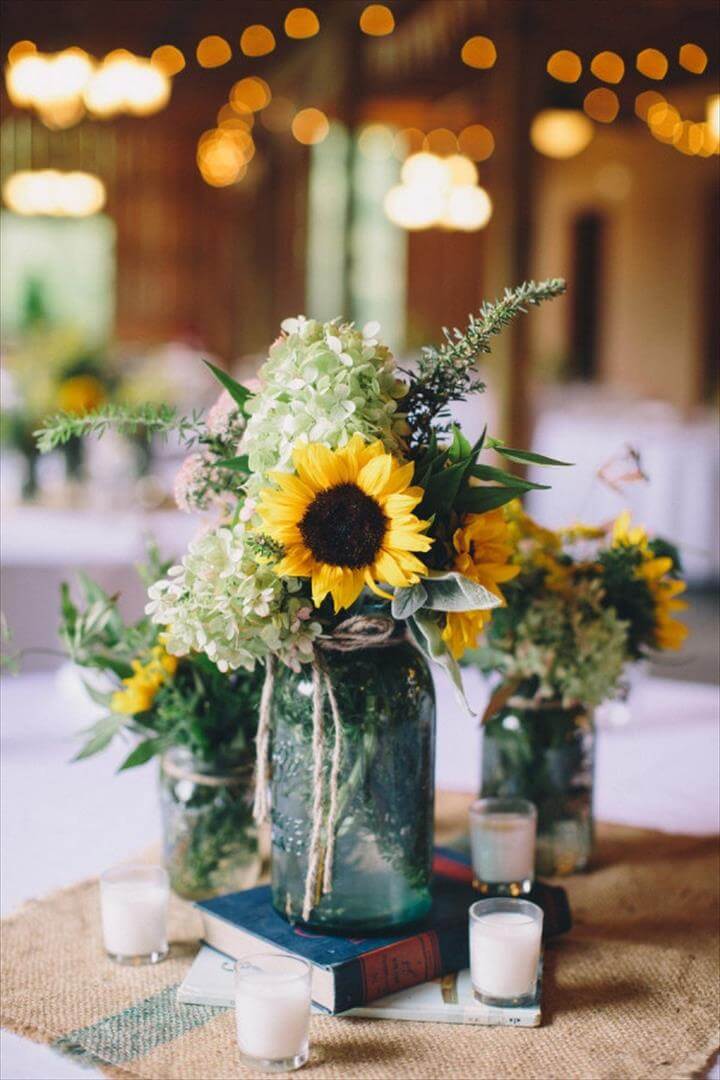 centerpieces with burlap square, aqua mason jars and books